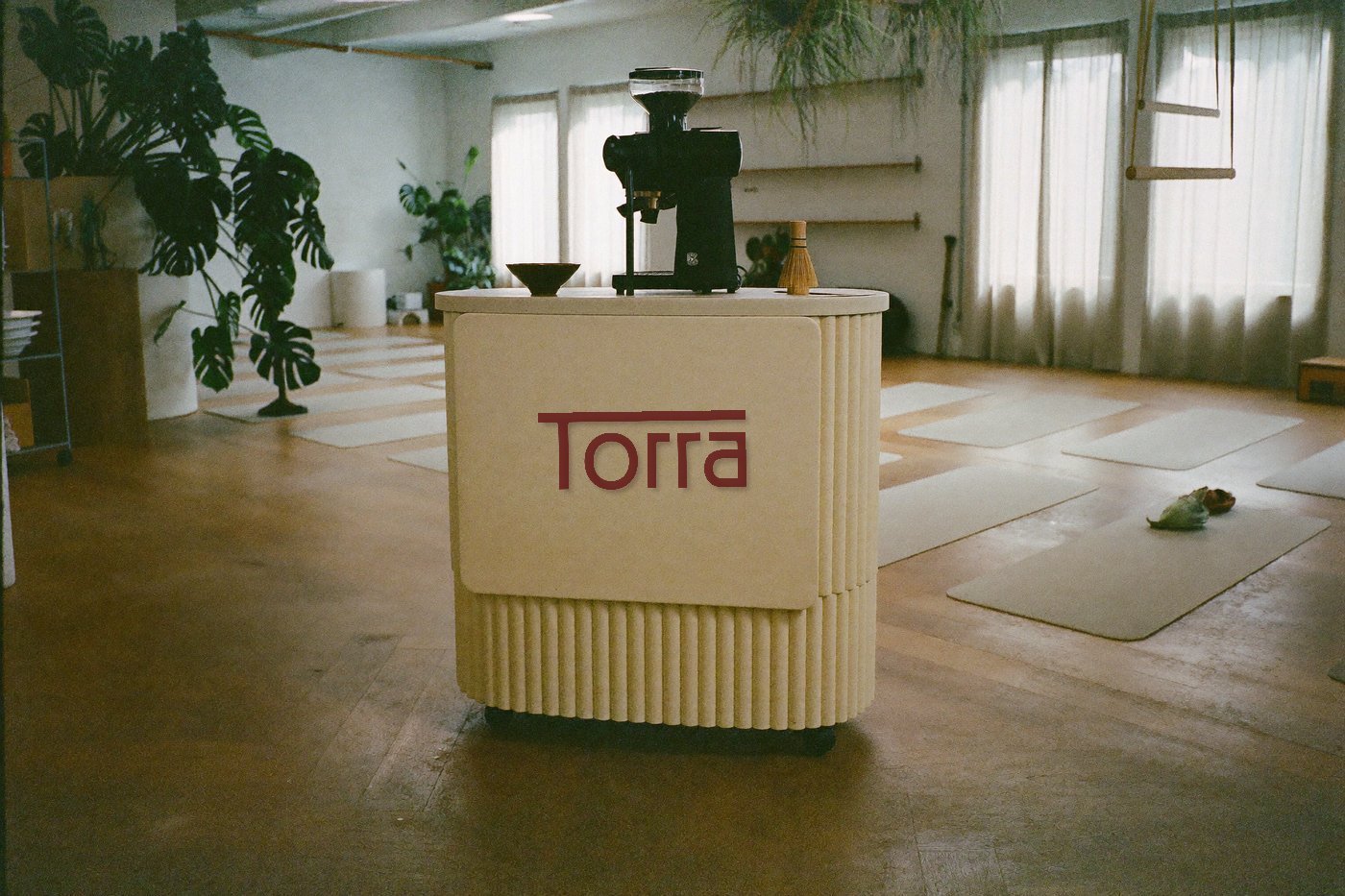 O carrinho da Torra montado na borda de um estúdio de yoga, com plantas e luz suave